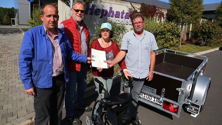 Bei der Übergabe der Fahrzeugpapiere für den Anhänger (von links): Jochen Trümner und Detlef Schwierzeck von den Hephata-Werkstätten mit Verena und Günther Richhardt, der den Hauptpreis der Verlosung bei den Hephata-Festtagen gewonnen hat. 