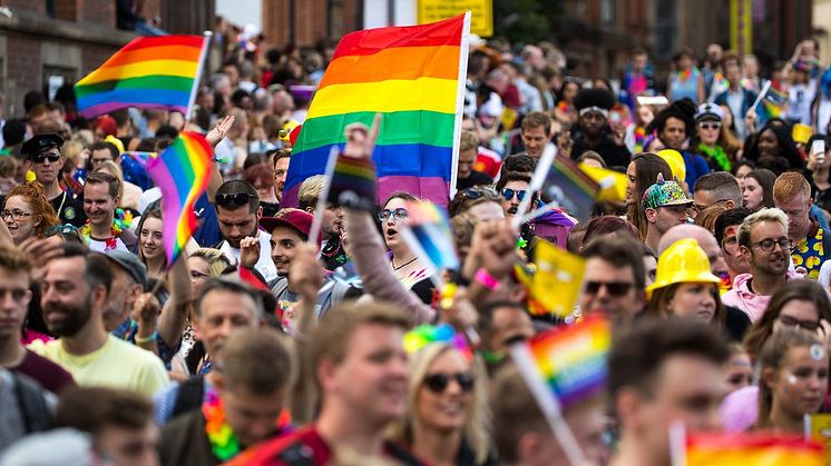 People walking for pride holding up rainbow flags