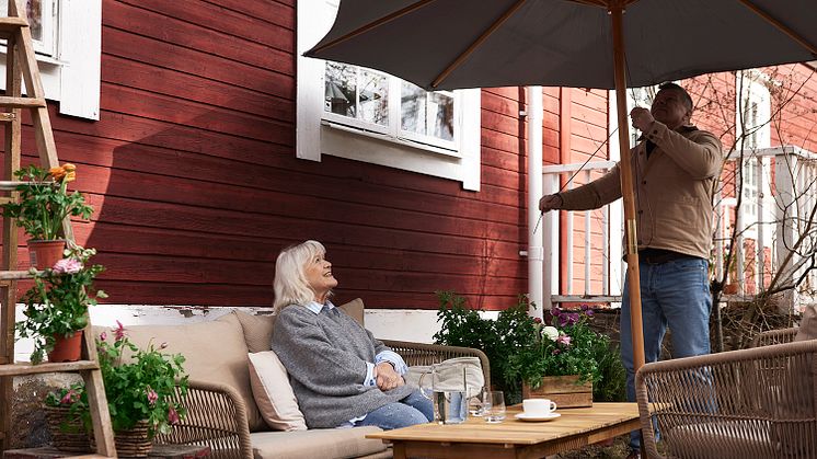 Christina och Jarmo i trädgården med parasoll