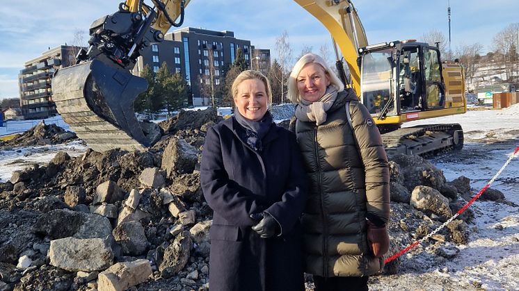 Byråd for Kultur og næring, Anita Leirvik North og administrerende direktør i Oslobygg Eli Grimsby foran den elektriske gravemaskinen som ble brukt til å ta første spadetak på Økern skole, flerbrukshall og barnehage.