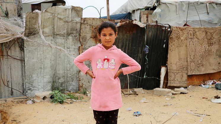 Ruba, 10 år, från Gaza står utanför det skjul som hon och hennes familj var tvungna att flytta till efter att deras hus blev bombat.