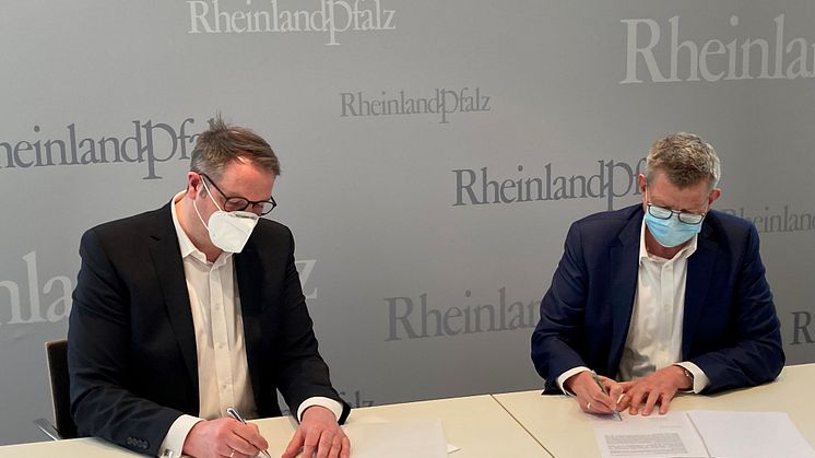 Alexander Schweitzer, Digitalminister von Rheinland-Pfalz und Thorsten Dirks, CEO von Deutsche Glasfaser unterschreiben die Absichtserklärung