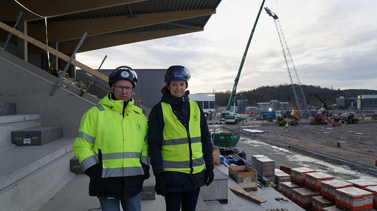 Projektledarna Anders Emilsson och Cecilia Wahlskog på den Östra läktaren av Rimnersvallen, i bakgrunden syns det första belysningstornet komma på plats.