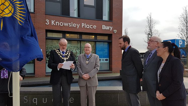 Civic leaders raise the Commonwealth Flag outside Knowsley Place