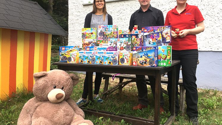 Luise Kuepper (Bärenherz), Frank Berthmann und Kerstin Walker (LBRICK e.V.) präsentieren stolz die neuen Logo-Spielsachen für Bärenherz