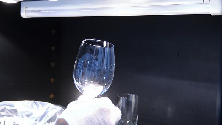 Grå hinna på glas och bestick efter disk bedöms i laboratoriets ljuskammare. 
