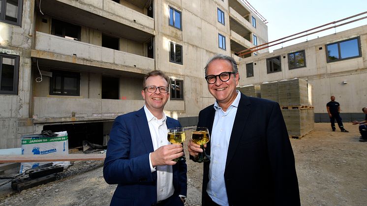 Dr. Bernd Hochberger (li.), Vorstandsmitglied der Stadtsparkasse München, stoßt zusammen mit dem Leiter des Immobilienmanagements, Michael Rubenbauer, auf das Richtfest des Neubaus in der Belgradstraße an.