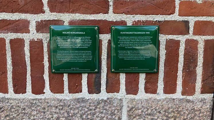 Två minnesskyltar vid huvudentrén på Borgarskolan