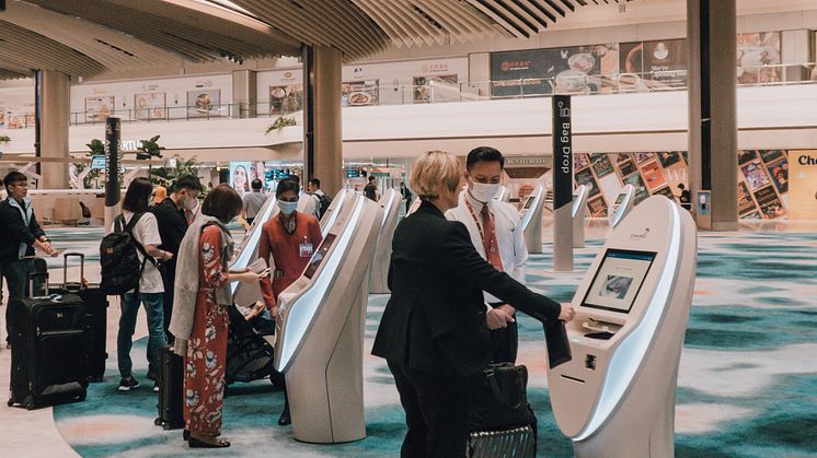 1. SIA passengers checking in for their flight at the automated check-in kiosks.