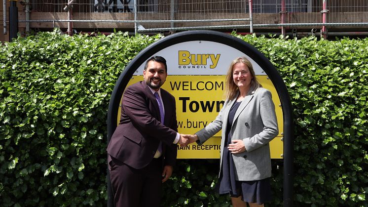 Cllr Tamoor Tariq and Cllr Lucy Smith shaking hands in front of Bury Town Hall