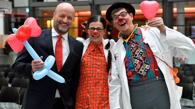 Ralf Fleischer, Vorstandsvorsitzender der Stadtsparkasse München mit zwei KlinikClowns.