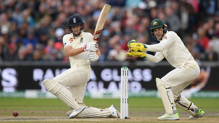England Test captain Joe Root (left) plays a sweep shot as Australian Test captain Tim Paine looks on (Getty Images)