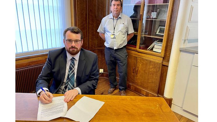 Council leader Eamonn O’Brien (seated) signs the joint GM letter on behalf of Bury, with (back) Cllr Alan Quinn.