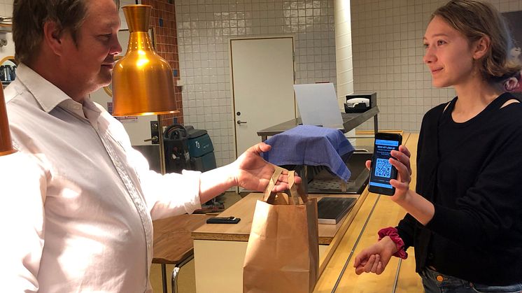 Mats Pettersson (Sodexo) lämnar ut lunchkasse till eleven Ebba Thurezon