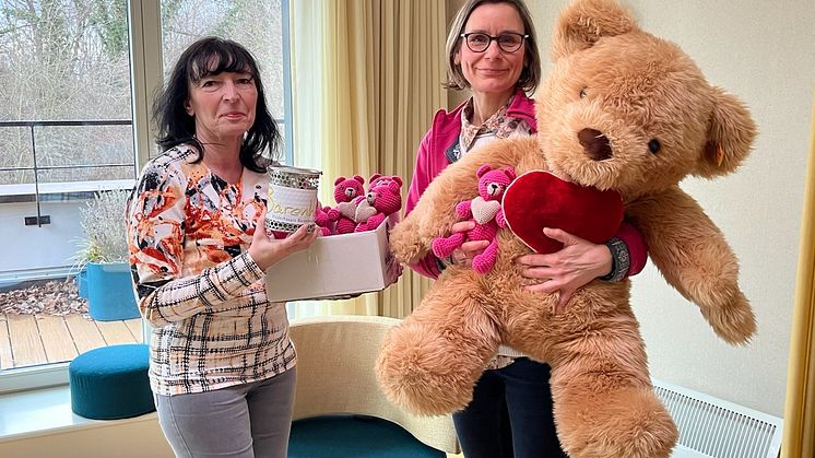Frau Schilling überreicht Anke Voigt eine volle Spendendose und pinkfarbene Herz-Bärchen