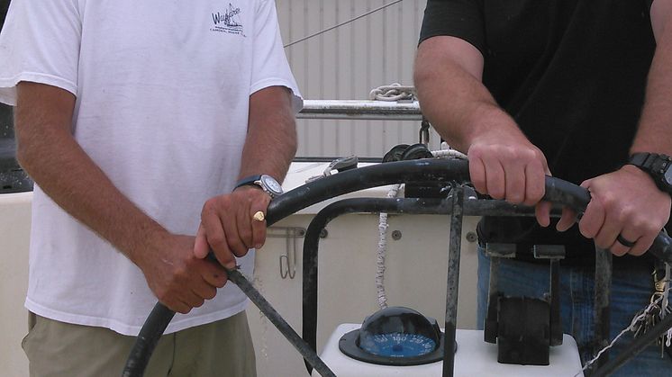 Hi-res image - ACR Electronics - Charles Nethersole with Capt. Cody Catapano, owner and captain of Sea Tow Crystal Coast, NC, on the recovered sailing catamaran Leopard.