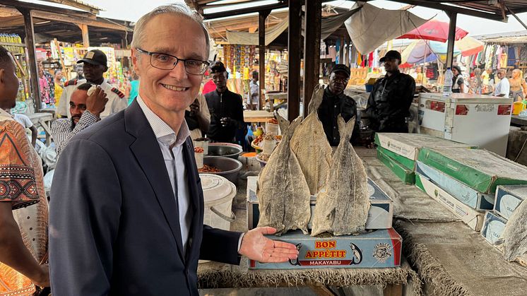 Ambassadør Odd Mølster med norsk klippfisk av sei på utendørsmarked i Kinshasa, DRK Kongo