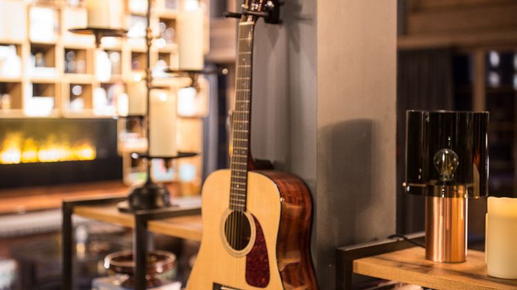 Gitarr och böcker i vardagsrummet på HUUS Hotel, Gstaad, designat av Stylt Trampoli