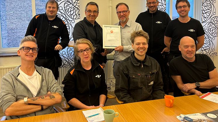 Dan Assarsson från JL Safety överlämnar samarbetscerifikat till Anders Johansson på BS Verkstäder tillsammans med medarbetarna som har fokus på förbättrad maskinsäkerhet.