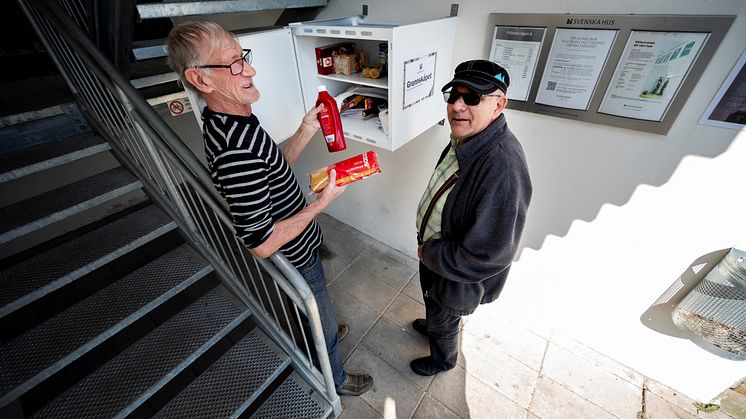 Grannarna Ingemar Olsson och Jan Jönsson visar exempel på varor som donerats till Grannskåpet.  Foto: Björn Lilja