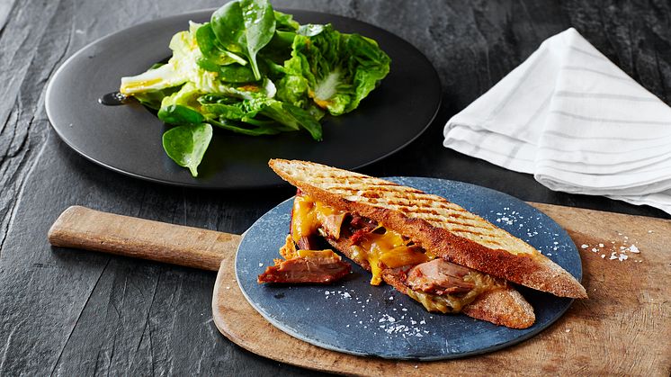 Smokey pork shank à la steak sandwich med karamelliserad lök och spröd sallad