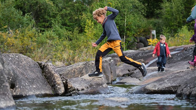 Boy jumping over a stream. Photo:  Matias Fosso