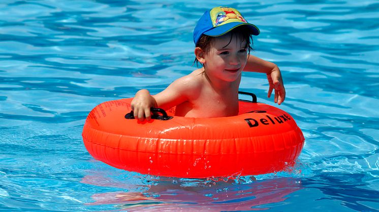 Zum Sonnenschutz für Kinder gehört immer eine Kopfbedeckung, die auch im Wasser getragen wird. Foto : SIGNAL IDUNA