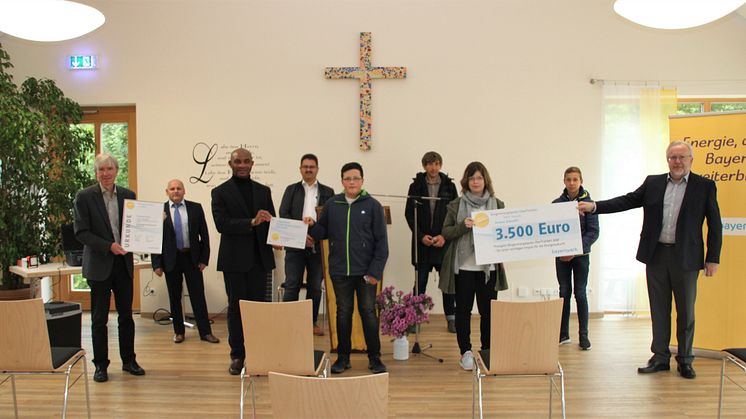 Freude in Ahorntal: Regierungsvizepräsident Thomas Engel (li.), Karl Krapf vom Bayernwerk (re.) sowie Vertreter aus Gemeinde und Landkreis übergeben den Ministranten um Pfarrer Dr. Matthew Anyanwu (3.v.li.) den Bürgerenergiepreis Oberfranken 2020.