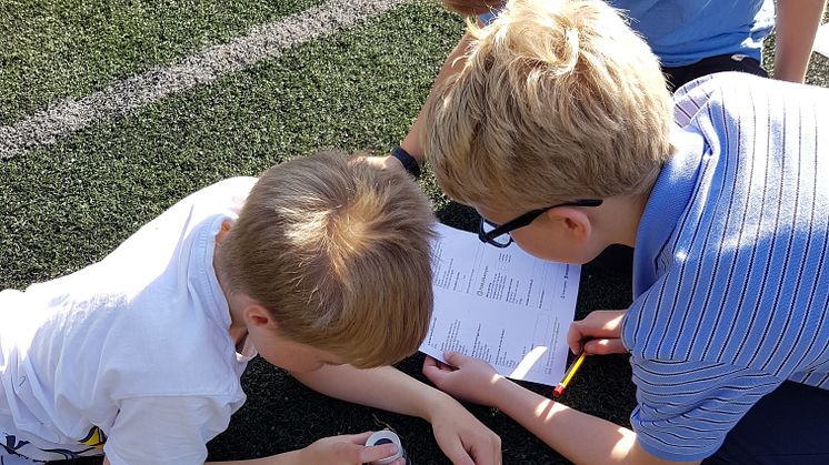 Elever ved Slåtten skole sjekker granulat på fotballbanen (Foto: Lillian Helleseth Furnes)