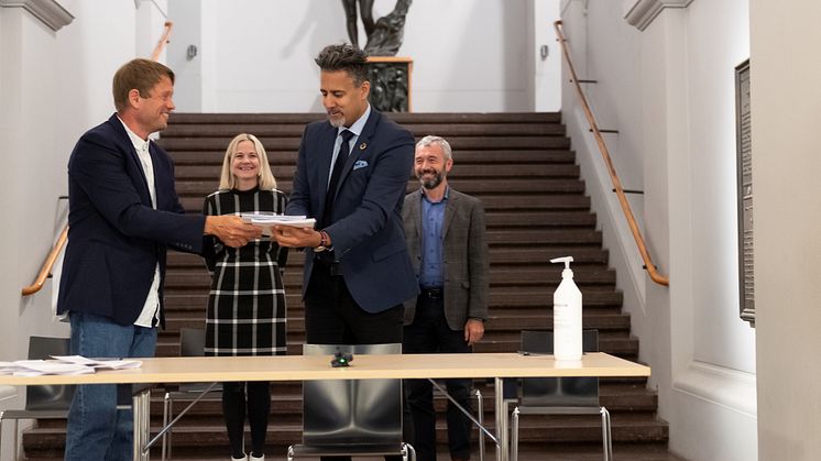 Prosjektleder Martin Eia-Revheim overleverer mulighetsstudien for Nasjonalgalleriet til kulturminister Abid Q. Raja. I bakgrunnen Nasjonalmuseets direktør Karin Hindsbo og Sparebankstiftelsen DNBs direktør André Støylen. (Foto: Frode Larsen)