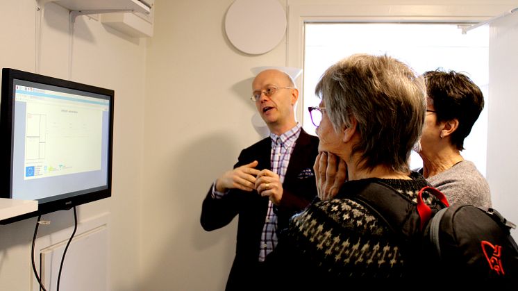 Jonas Melin visar tekniken i testlägenheten för besökare.