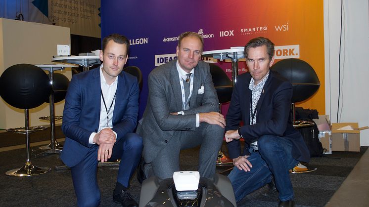 Tobias Söderlund, till vänster, och Jan-Åke Lindqvist, till höger, från WSI tillsammans med Rikard Florin från Telit. Framför dem, i vitt ovanpå robotgräsklipparen från Husqvarna, syns den smarta miljösensorn.