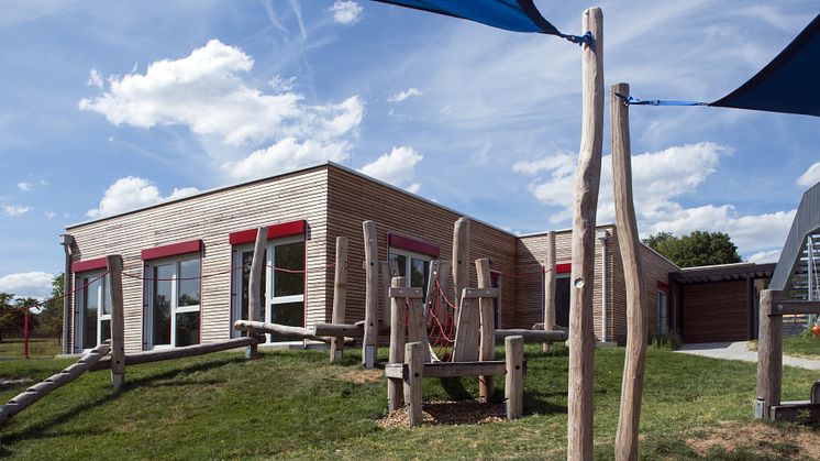  Architektur im Einklang mit der Natur. Die von Algeco in Modulbauweise errichtete Kita Walddorfhäslach fügt sich nahtlos in die angrenzende Umgebung mit ihren Wiesen, Feldern und Bäumen ein.