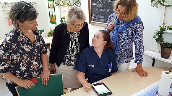 ​Susanne Edfors, undersköterska på Enebergs äldreboende, demonstrerar appen för Eva Nagy, Ulla Frisk och Christina Engius från Arbetsmiljölyftet.