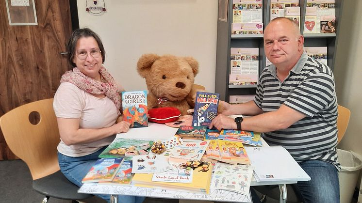 Kerstin Stadler vom Kinderhospiz und Carsten Pergande präsentieren die Sachspenden der Buchhandlung Ludwig