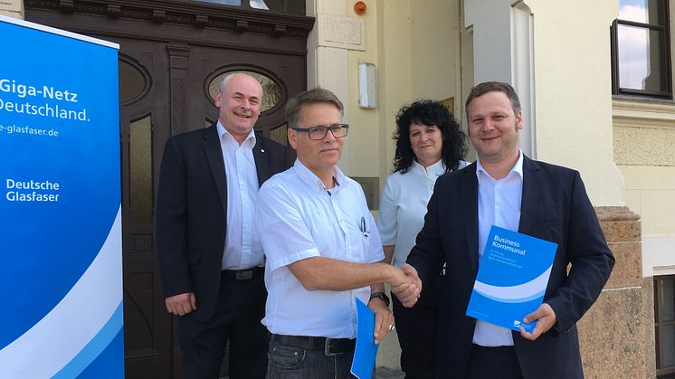 Gemeinsam besiegeln Schulleiterin Silke Kirsten und Bürgermeister Arno Jesse die Zusammenarbeit mit Deutsche Glasfaser - Stephan Luerweg, Kundenberater für Kommunales (neben BM Jesse) und Oliver Frieske, Projektmanager FTTH (hinten im Bild)