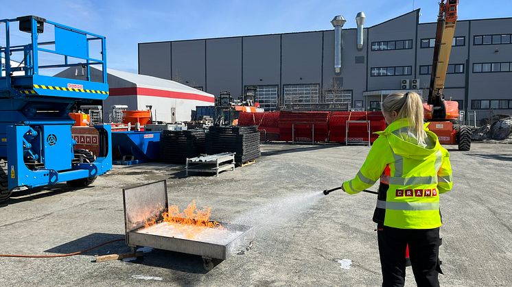Øvelse brannslukking.jpg: Øvelse gjør mester. Her trener Cramo-medarbeider på å slokke en brann dersom ulykken skulle være ute. (foto:Cramo)