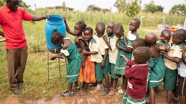 Barn på förskola i Uganda tvättar händerna. 