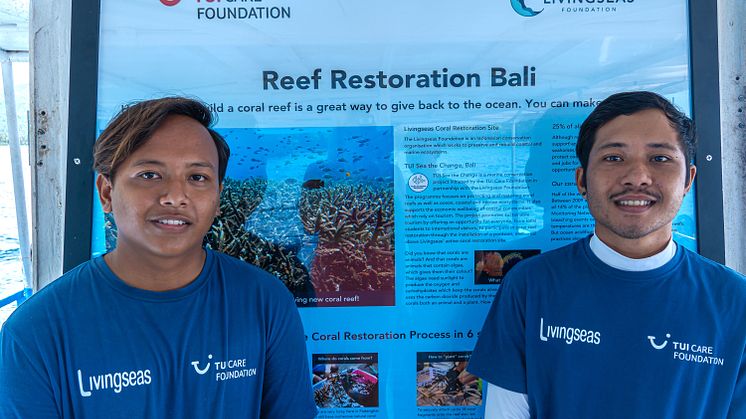 aksi henkilöä seisoo "Reef Restoration Bali" -julisteen edessä, yllään siniset TUI Care Foundation ja Livingseas -logopaidat.