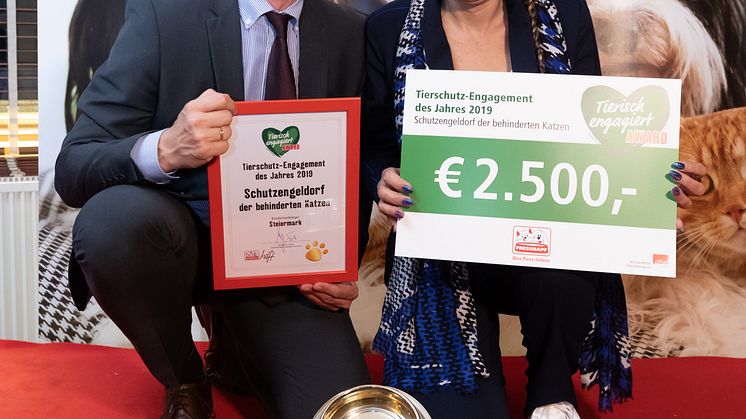 Hermann Aigner übergibt den goldenen Fressnapf an Renate Riedel vom Schutzengeldorf der behinderten Katzen