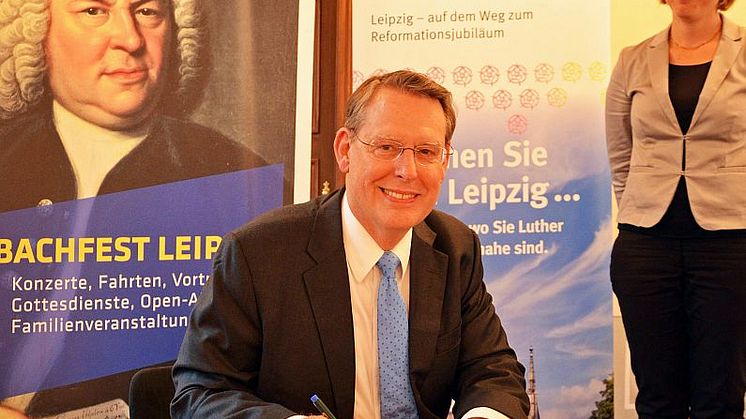 Reverend Dr. Robert Moore unterzeichnet seinen Vertrag als Leipzigs Reformationsbotschafter