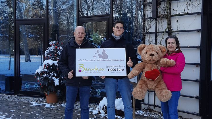 Karlheinz und Tim Latotzke präsentieren stolz mit Kerstin Stadler vom Bärenherz ihren Spendenscheck vor dem Kinderhospiz