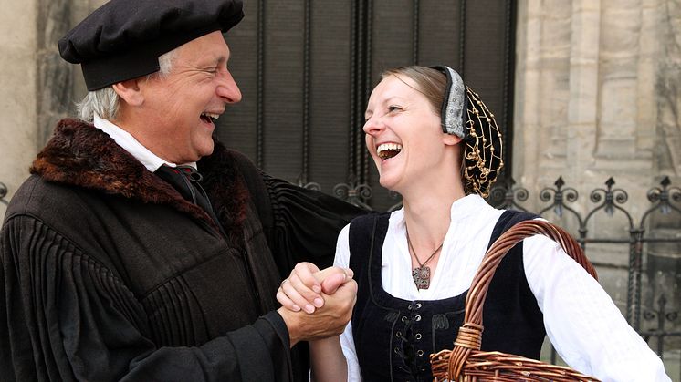 Luther och von Bora framför slottskyrkans tesportal i Wittenberg. © IMG Sachsen-Anhalt/Foto: J. Blume
