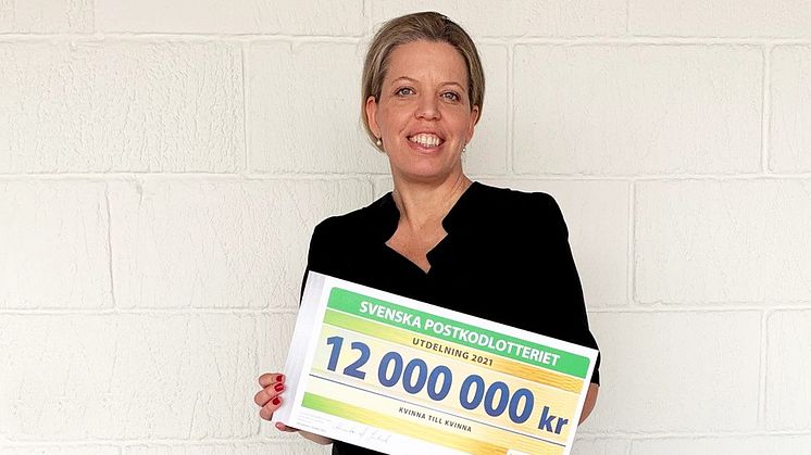 Kvinna till Kvinnas generalsekreterare Petra Tötterman Andorff mottar årets check från Postkodlotteriet på tolv miljoner kronor.