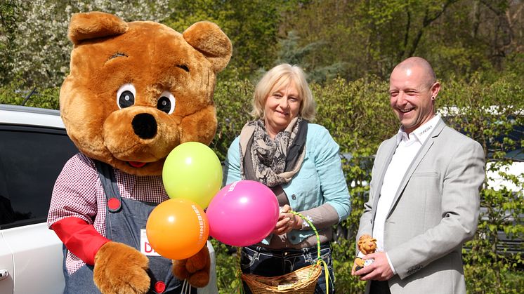 Elvira Wegner vom Kinderhospiz mit Christian Pohlers, Markenverantwortlicher von Suzuki in der Markkleeberger Autohaus Dinnebier Filiale und Suzuki Maskottchen Disu. Der Name des Bären ist aus den Begriffen Dinnebier und Suzuki entstanden.