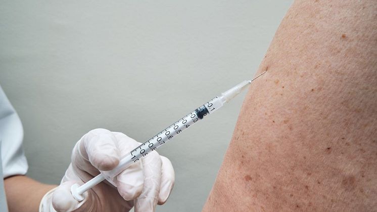 Äldre person får vaccin av vårdpersonal 