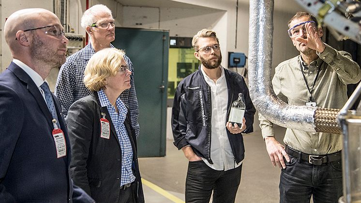 Håkan Schmidt, GKN visar RM12-motorn för fr v Håkan Johansson, Försvarsmaktens Hållbarhetssektion, Ingela Bolin Holmberg, FMV, Torbjörn Hillerström, och Fredrik Lundgren med ett biobränsleprov i handen, båda GKN. Foto: Jukka Lamminluoto.