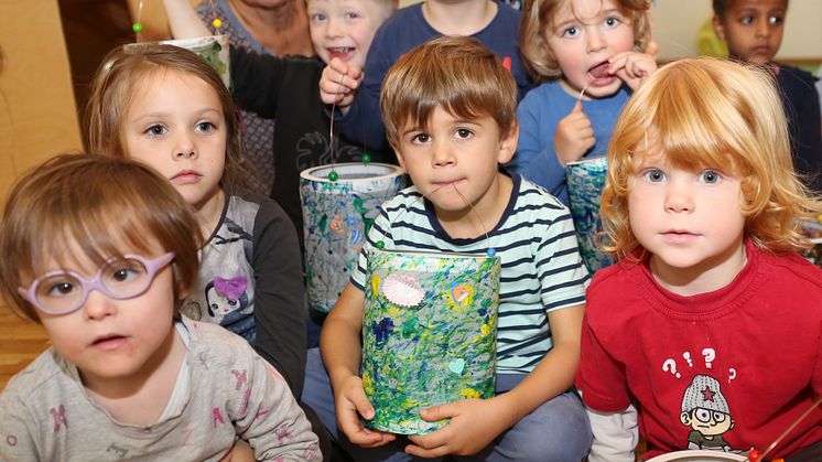 Erzieherin Jutta Linzner freut sich mit den Kindern der Mondgruppe der Hephata-Kita über die gebastelten Laternen.
