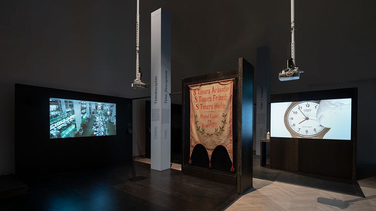 Banner with text, ”8 Hours’ Work! 8 Hours’ Freedom! 8 Hours’ Rest!”, ca. 1914. Revital Cohen, Tuur Van Balen, 75 Watt, 2013. Marcus Coates, Self Portrait as Time, 2016