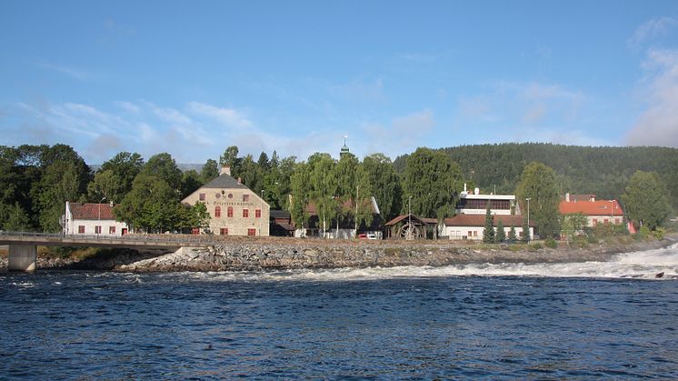 Det Norske Myntverket og Norsk Bergverksmuseum sett fra Lågen. Foto: Norsk Bergverksmuseum